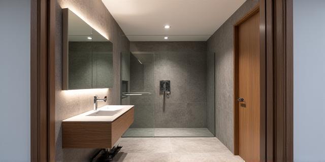 Sleek, minimalist bathroom design with a floating vanity and walk-in shower in a modern Dublin apartment.